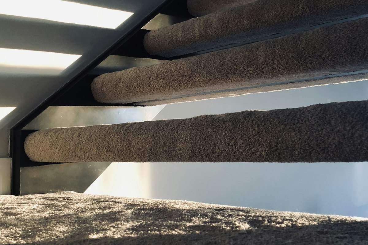 Open stair treads with carpet wrapped tightly around each nosing