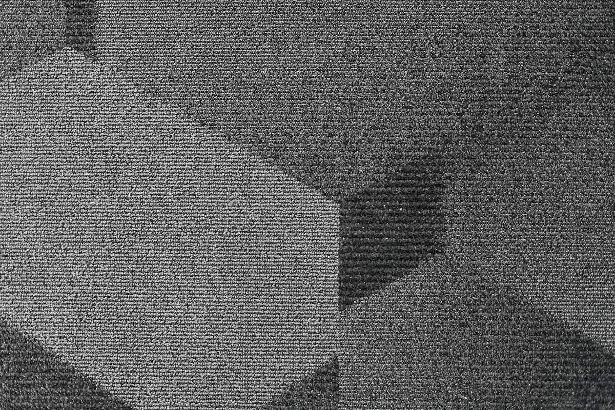 Close-up of gray commercial carpet tile with a geometric pattern