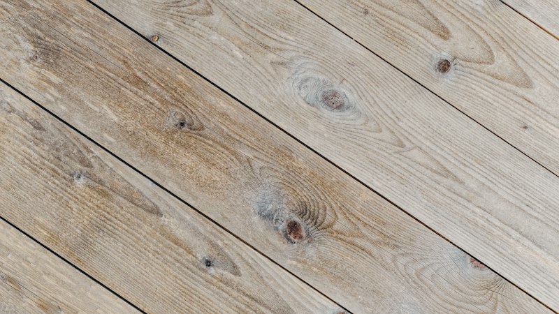Close-up of weathered, wire-brushed style wood floorboards with visible knots and grain