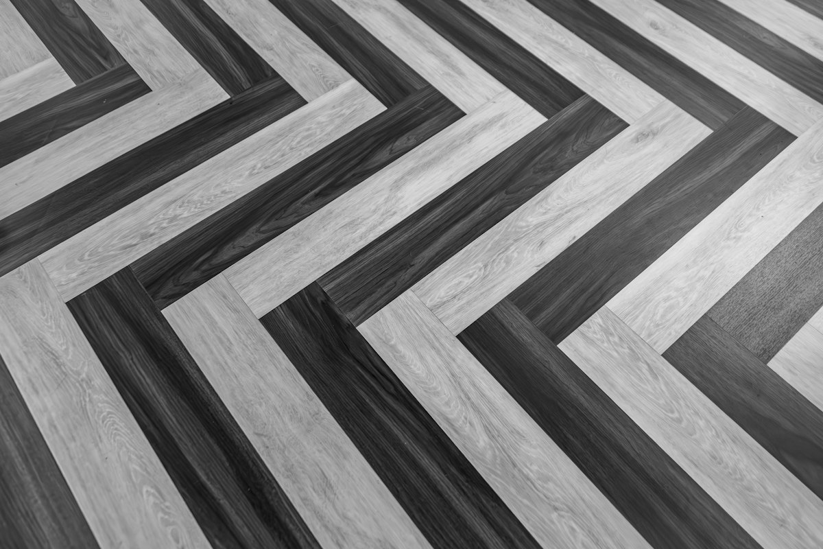 Gray and white wood-look planks laid in a herringbone zigzag