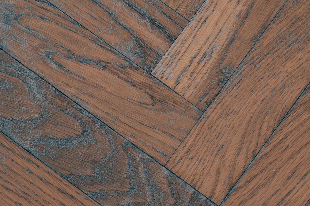 Close-up of herringbone hardwood boards meeting at square-ended joints
