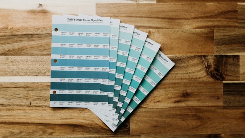 Paint color swatches fanned out on a wood floor while planning a home renovation